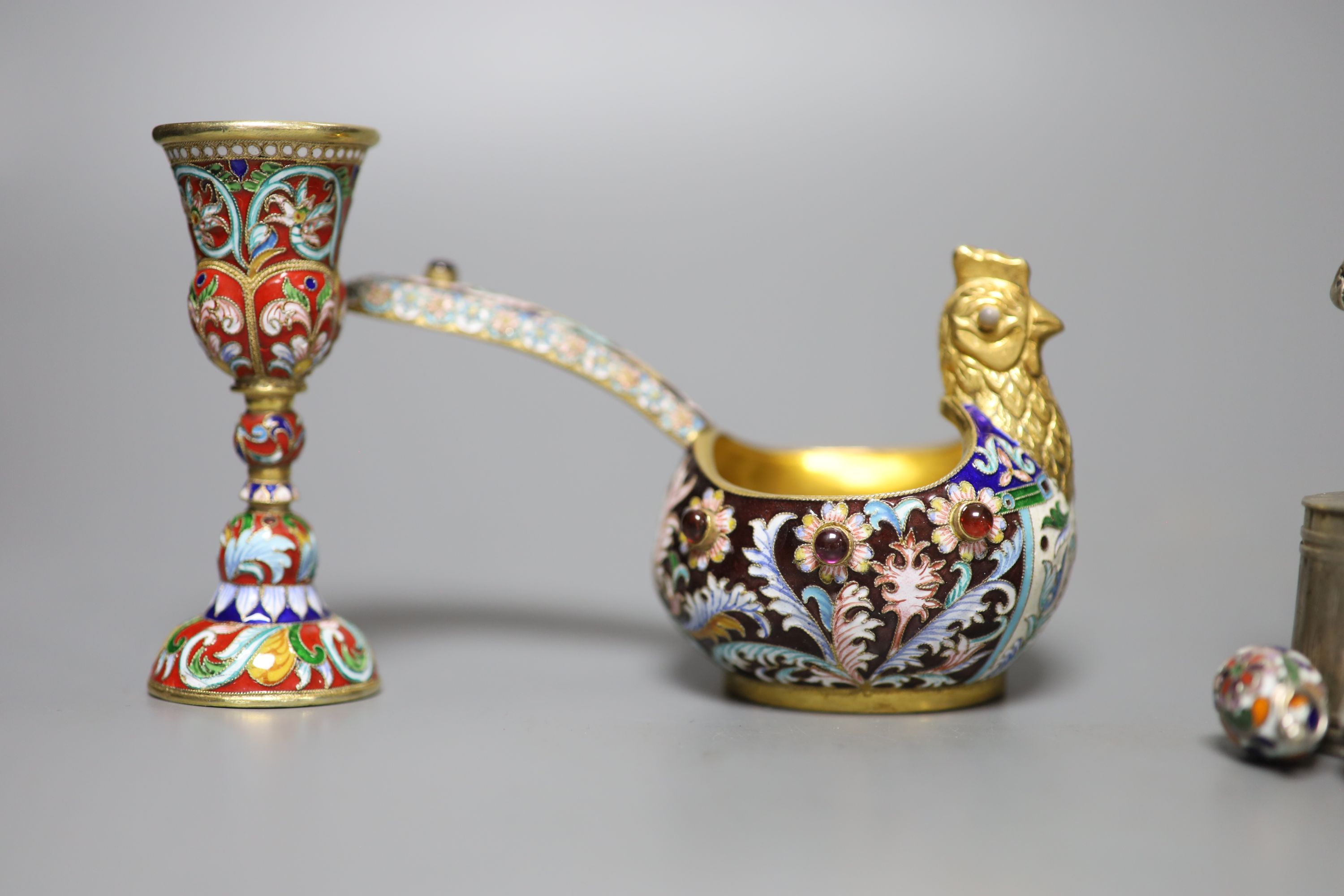 A group of Russian style white metal and enamel items including kovshs, egg pendants and small cups.